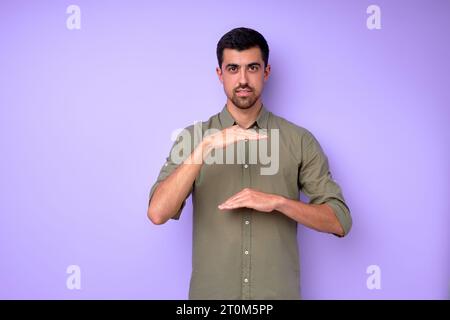 Young deaf mute man saying celling using sign language on blue background, close up portrait isolated building house concept Stock Photo