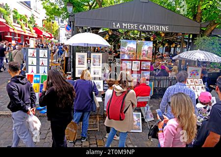 Tourists inspecting works of art by various artists in Place Tertre in the Montmartre district of Paris Stock Photo