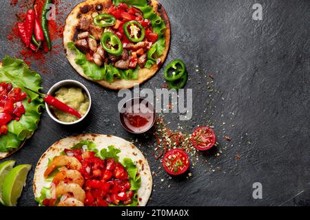 Tacos with salsa, vegetables and avocado on black background. Copy space. Stock Photo