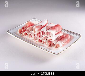 fresh and aesthethic bacon rolls on a white plate. View from above. Chinese cuisine, ingredient for hotpot Stock Photo