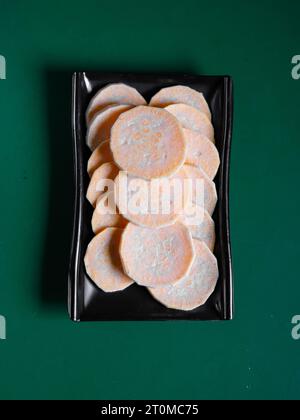 sweet potato slices on a black plate. View from above. Chinese cuisine, ingredient for hotpot Stock Photo