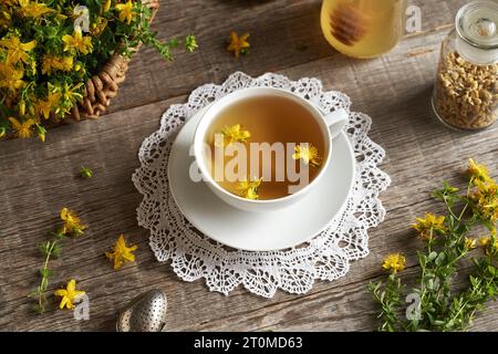 A white cup of herbal tea with fresh St. John'w wort flowers Stock Photo