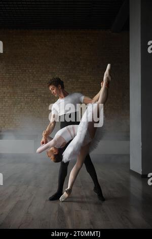 Graceful couple of ballet dancers performing against studio background Stock Photo