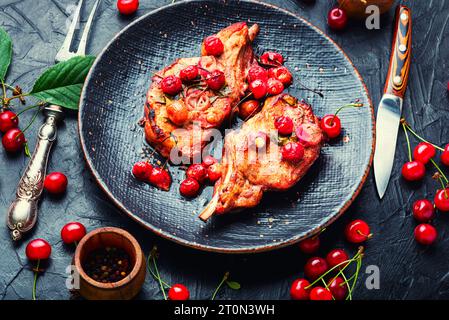 Two cooked steaks in a cherry marinade. Grilled meat with berry sauce Stock Photo