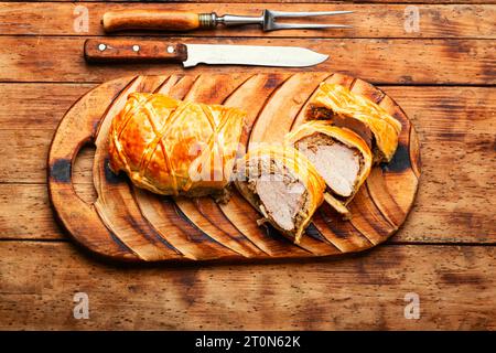 Meat dish is wellington meat, meat baked in dough. Meat loafs on old wooden table Stock Photo
