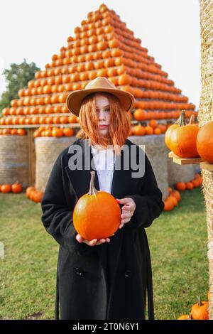 red-haired girl hold pumping in the pumping farm market Stock Photo
