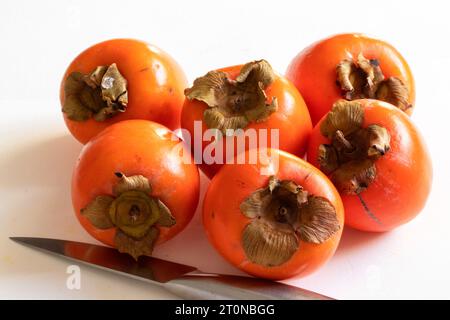 Persimmon fruit in a heap on a white background Stock Photo