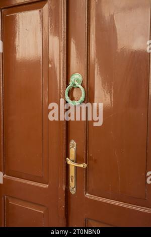 Closeup of a wooden double door with metal hardware and antique cast iron door knocker in the Old Town of Rhodes, Greece Stock Photo