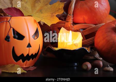 Happy Halloween. A plastic pumpkin bucket with an evil smiling. Halloween horror concept. Ripe pumpkins in a basket in the light of a candle, horror c Stock Photo