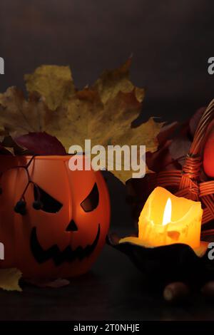 Happy Halloween. A plastic pumpkin bucket with an evil smiling. Halloween horror concept. Ripe pumpkins in a basket in the light of a candle, horror c Stock Photo