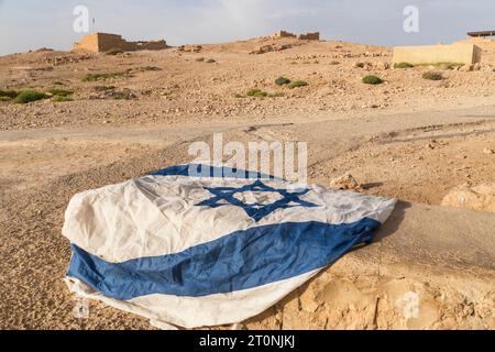 The rumpled Israeli flag left on the dry soil Israel. The national symbol of Israel Patriotic feeling. Nation Stock Photo