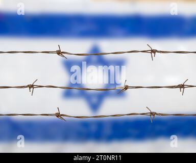 Metal fence with barbed wire on a Israeli flag. Separation concept, borders protectionm. Stock Photo
