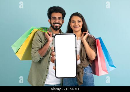 Cheerful indian couple using nice shopping mobile app, copy space Stock Photo