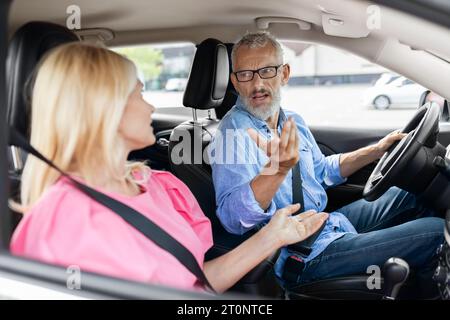 Emotional retired couple arguing, shouting at each other in car Stock Photo