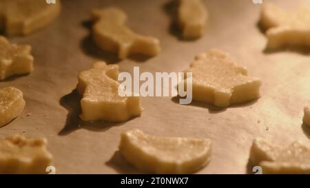 Process of baking cookies from puff pastry in the oven. Cooking cookies in the shape of a heart, an Easter bunny and other animals Stock Photo
