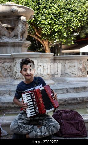 A boy playing an accordion in Iraklio, Crete Stock Photo