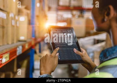 Software Smart warehouse management in tablet computer real time monitoring track goods package delivery. Inventory worker showing digital data dashbo Stock Photo