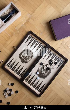 Backgammon board on the floor surrounded by props Stock Photo