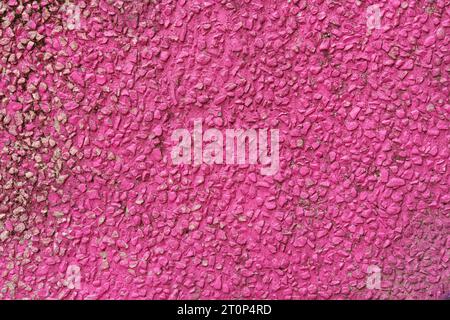 The texture of a wall made of fine gravel painted red. Backgrounds and textures. Stock Photo