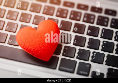 Red heart on laptop keyboard flirt love chat or lover online text messenger for meeting date Stock Photo