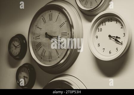 classic old times memory concept. many retro style time clocks hanging on the wall vintage color tone Stock Photo