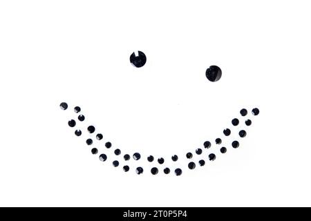 Lopsided smile face made of round black dots isolated over white Stock Photo