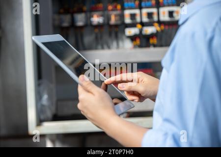 Electrician Engineer using  software check service maintenance electricity main circuit fuse and power system in industry factory Stock Photo