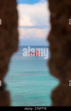 Poseidon Submarine boat mid tour departing from Mandraki Harbor viewed from a window hole in the city's fortress Stock Photo