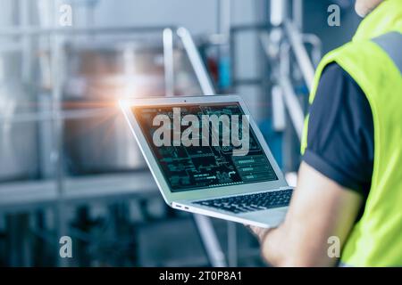 Engineer with laptop high technology software for industrial factory automation operate control service machine working monitor. Stock Photo