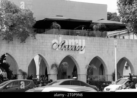 Aktaion restaurant and cafe front entrance sign located across from the Mandraki Marina and Port in black and white Stock Photo