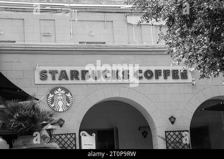 Black and white Starbucks coffee shop chain storefront entrance and sign located in Rhodes city, Greece Stock Photo