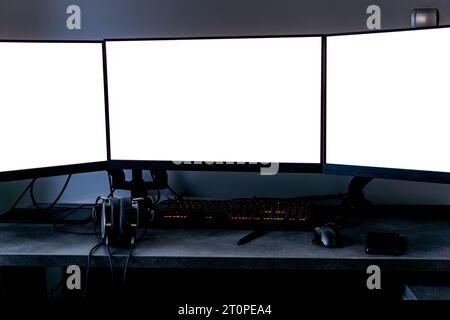 tree empty monitors mock-up on a desk headphones, keyboard, mouse, and tablet Stock Photo