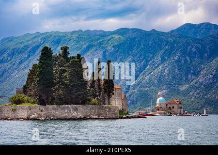 The monestery on the Island of Saint George stands out in the Bay of Kotor near Perast, Montenegro with Our Lady of the Rocks in the distance nearby. Stock Photo