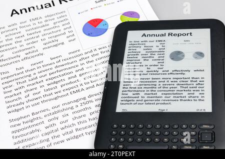 E-reader showing a company annual report with a printed copy Stock Photo