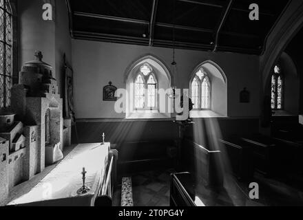 ST.HILARY CHURCH SUNLIGHT STREAMING THROUGH THE WINDOW ILLUMINATING STATUE OF JESUS Stock Photo