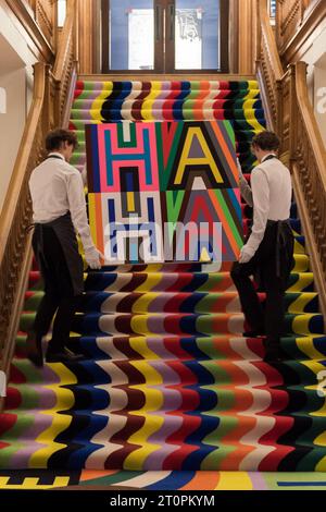 London, UK. 06th Oct, 2023. LONDON, UNITED KINGDOM - OCTOBER 06, 2023: Art handlers carry an artwork by Lakwena Maciver titled 'Know who we are', 2022, estimate £8,000-12,000 over the installation TENDER, LOVING, CARE, 2023, during a photocall at Christie's auction house for the first artist's takeover of the historic headquarters in St James's in London, United Kingdom on October 06, 2023. (Photo by WIktor Szymanowicz/NurPhoto) Credit: NurPhoto SRL/Alamy Live News Stock Photo