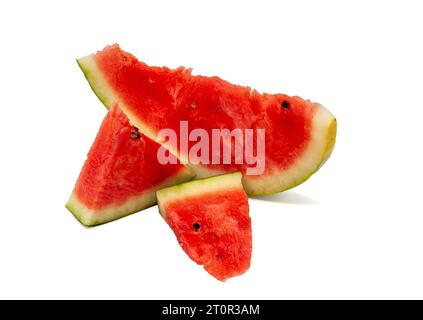 Three slices of red ripe and sweet watermelon in different sizes with black seeds and rind on a white background. Stock Photo