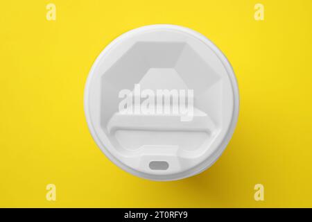 One paper cup with white lid on yellow background, top view. Coffee to go Stock Photo