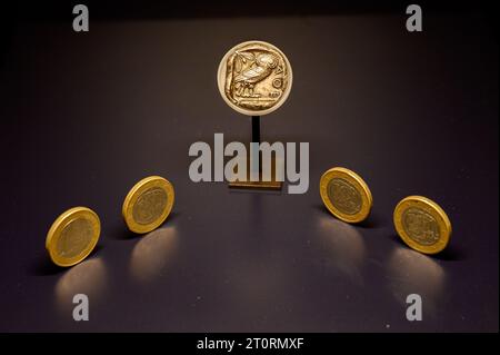 Silver tetradrachm coin depicting the owl of Athena. Circa 448-415 BC. Displayed with Greek euro coins from 2000s. Musée national d'archéologie, d'his Stock Photo