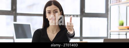 Successful manager sits near open laptop showing thumb up Stock Photo