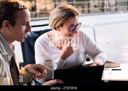woman and man working together while having coffee Stock Photo