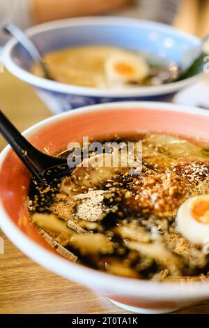 Two bowls of tonkotsu ramen (shoyu base and black garlic oil) with soft-boiled eggs, bamboo shoot and warabi at Mikazuki Japanese restaurant in Sydney Stock Photo