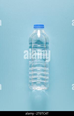 plastic water bottle with blue cap on blue isolated background Stock Photo