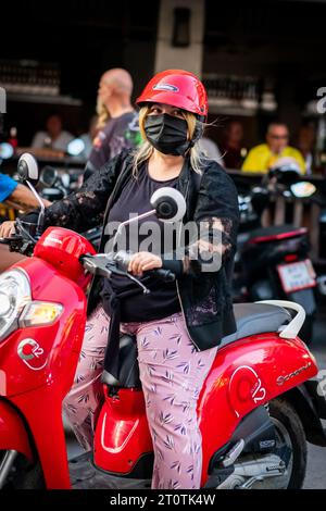 Local Thai people, tourists and residents rush past the busy junction of Soi Buakhao and Soi Lengkee in Pattaya Thailand on mopeds and motorbikes. Stock Photo