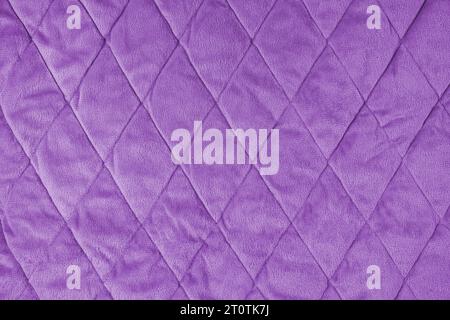 Quilted velours fabric background. Violet texture blanket or puffer jacket, stiched with diamond pattern, soft wrinkled surface, crupmed textile Stock Photo