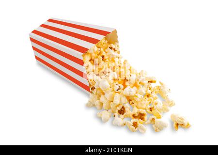 Tasty cheese popcorn falling out of a red striped carton bucket, isolated on white background. Scattering of popcorn grains. Movies, cinema and entert Stock Photo