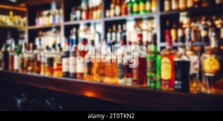 blurred alcohol bottles on bar counter and in shelves in background Stock Photo