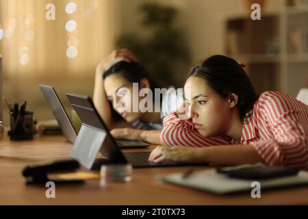 Tired tele workers in the night working late hours at home Stock Photo