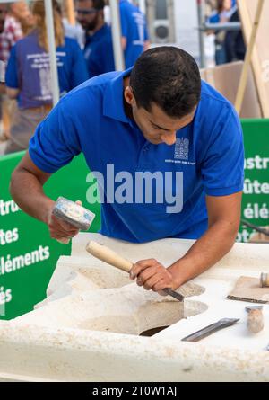 A skilled stonemason works on a new gothic-style stone carving to be used on Notre Dame Cathedral in Paris, France, which is being rebuilt after a dev Stock Photo