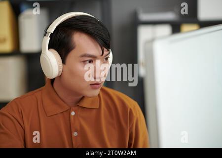 Portrait of developer reviewing programming code on computer screen Stock Photo